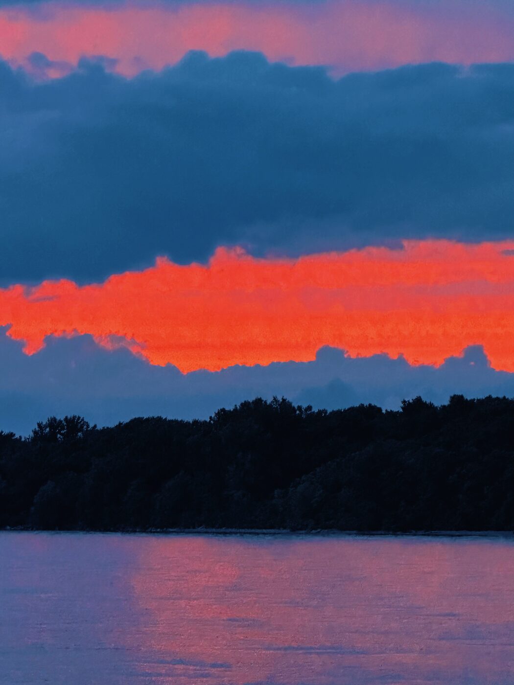 Vivid red sunset clouds over a dark lake